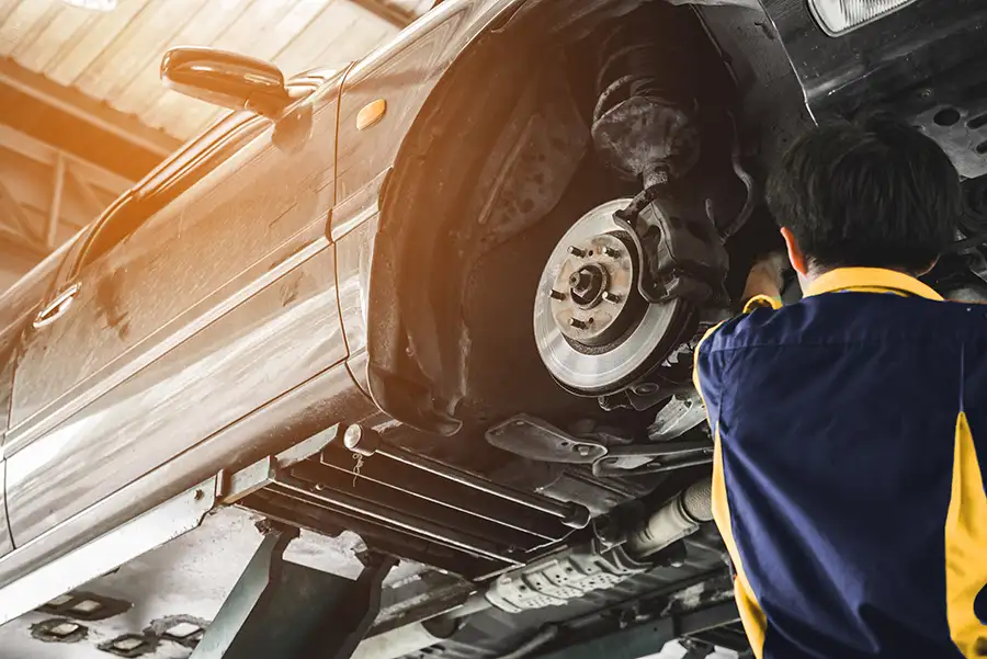 Professional mechanic inspecting and repairing/replacing brakes on car - Forsyth, IL